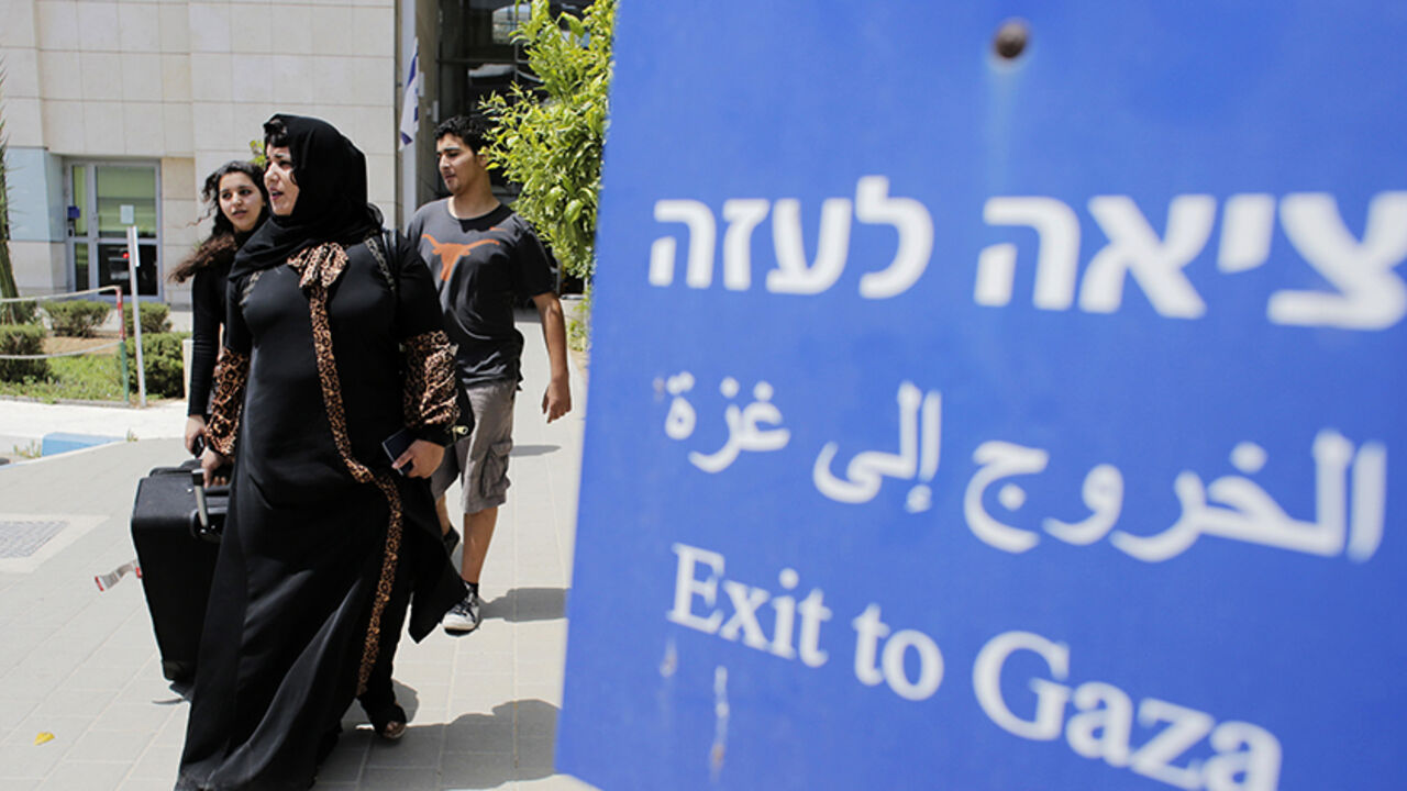 Palestinians walk out of Israel's Erez Crossing after leaving Gaza July 13, 2014. According to a spokesperson for Israel's Coordination of Government Activities in the Territories (COGAT), about 850 Palestinians with dual citizenship left Gaza on Sunday at the request of their foreign embassies. Israeli naval commandos clashed with Hamas militants in a raid on the coast of the Gaza Strip on Sunday, in what appeared to be the first ground assault of a six-day Israeli offensive on the territory aimed at stopp