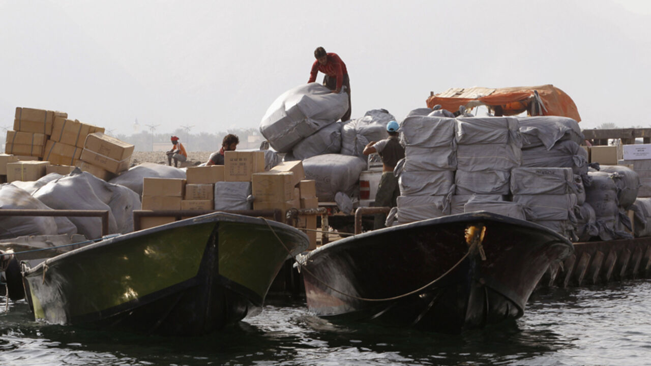 Iranian smugglers load goods at the Omani port of Khasab September 26, 2012. Until recently the Iranian boats and their fearless young skippers escorted several cargoes a day across the narrow Strait of Hormuz - loaded with everything from soft drinks to mobile phones and cosmetics - bought in the flourishing trading centres of the United Arab Emirates and sold to merchants in Iran. The proximity of Iran to the UAE and Oman and their historic trade and finance links have supported thriving trade, which in r