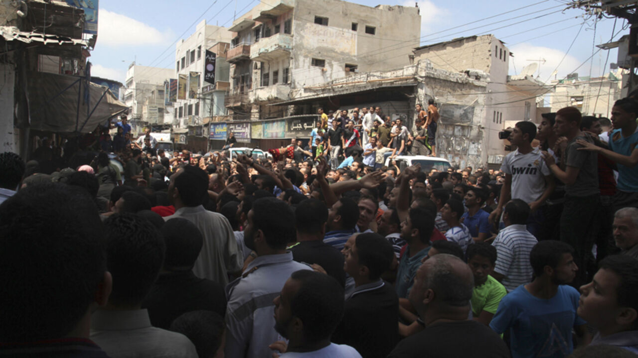Palestinians watch as Hamas militants execute Palestinians suspected of collaborating with Israel, in Gaza City August 22, 2014. Hamas militants killed seven Palestinians suspected of collaborating with Israel in a public execution in a central Gaza square on Friday, witnesses and a Hamas website said. The victims, their heads covered and hands tied, were shot dead by masked gunmen dressed in black in front of a crowd of worshippers outside a mosque after prayers, witnesses and al-Majd, a pro-Hamas website,