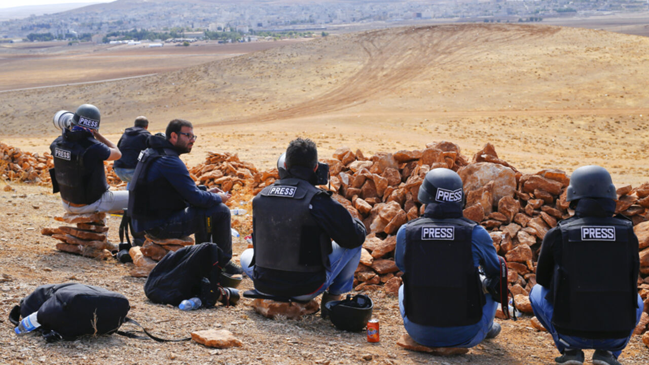 Photographers and members of the media watch the Syrian town of Kobani from atop a hill on the Turkish-Syrian border in the southeastern town of Suruc in Sanliurfa province October 15, 2014. American-led forces sharply intensified air strikes against Islamic State fighters threatening Kurds on Syria's Turkish border on Monday and Tuesday after the jihadists' advance began to destabilise Turkey.   REUTERS/Kai Pfaffenbach (TURKEY  - Tags: CONFLICT POLITICS)   - RTR4A8TR
