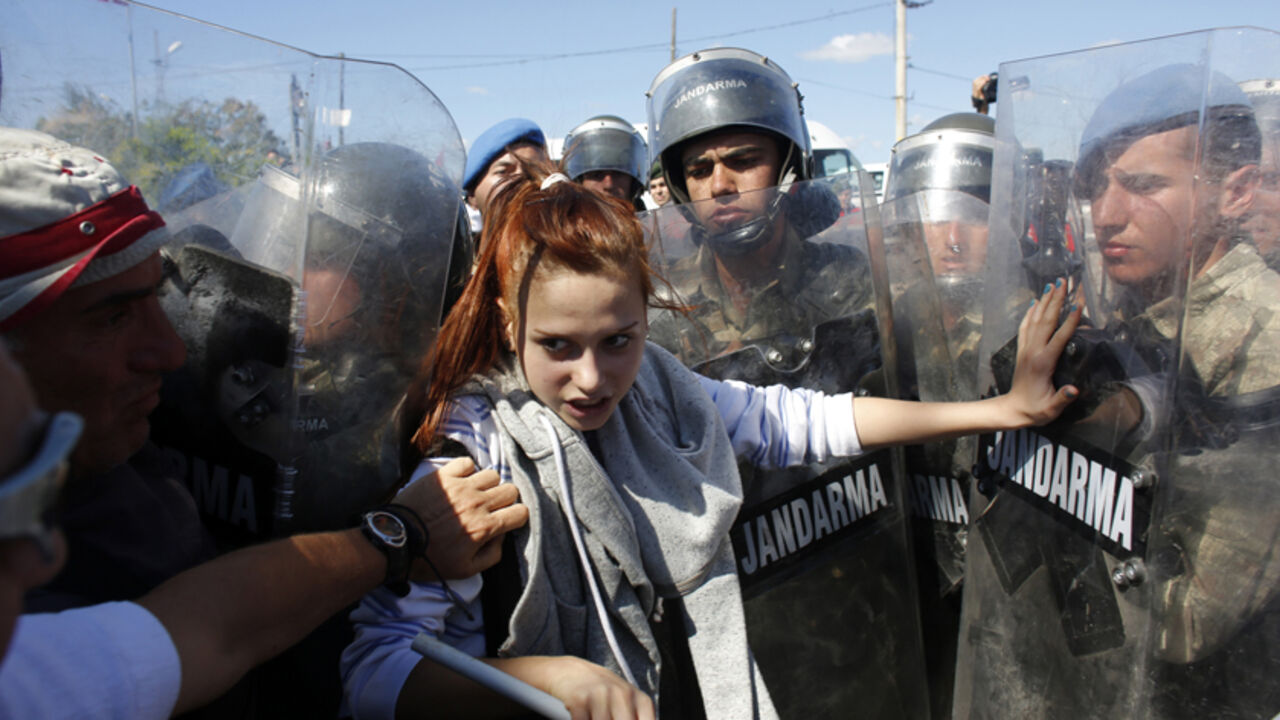 A protester stands against Turkish soldiers during clashes near Silivri, where a hearing on people charged with attempting to overthrow Prime Minister Tayyip Erdogan's Islamist-rooted government is due to take place August 5, 2013. A Turkish court on Monday sentenced a former military commander to life in prison and dozens of others including opposition members of parliament to long terms for plotting against the government, in a case that has exposed deep divisions in the country. Retired military chief of