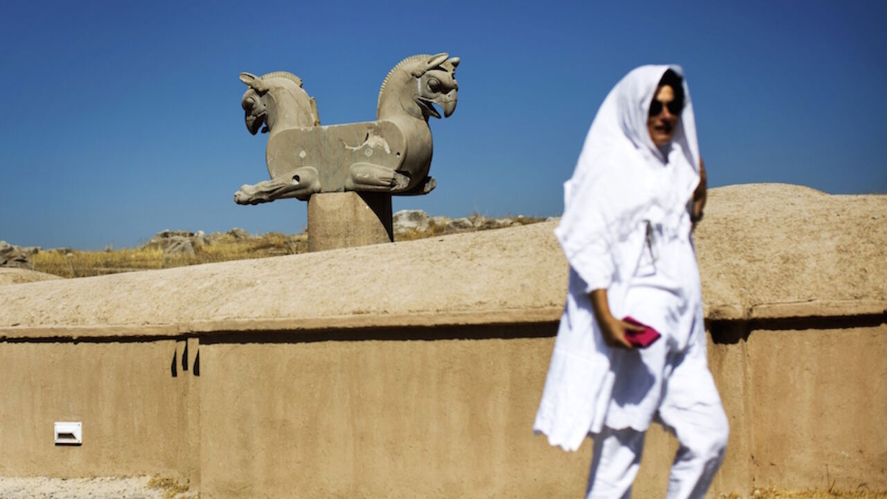 TO GO WITH AFP STORY BY SIAVOSH GHAZI
A Spanish tourist walks past an Achaemenid griffin at the ancient Persian city of Persepolis near Shiraz in southern Iran on September 26, 2014. At the foot of Persepolis, the giant sun-dried brick ceremonial capital of the Achaemenid and first Persian empire, foreign tourists pour out of buses and gaze in wonder. AFP PHOTO/BEHROUZ MEHRI        (Photo credit should read BEHROUZ MEHRI/AFP/Getty Images)