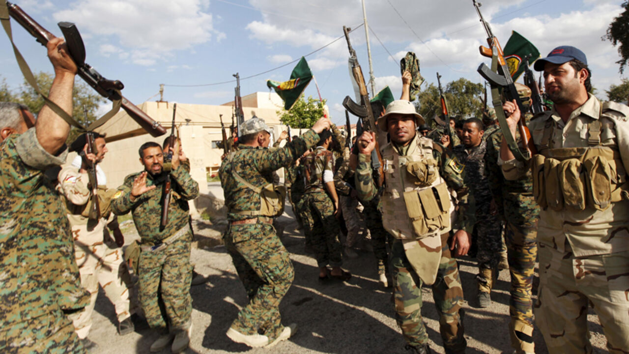 Shi'ite paramilitary fighters chant slogans as they celebrate victory in Tikrit April 2, 2015.  The Iraqi security forces parade through the streets of Tikrit Thursday - a day after the Iraqi government claimed victory over Islamic State insurgents in the city.  REUTERS/Ahmed Saad - RTR4VXHX