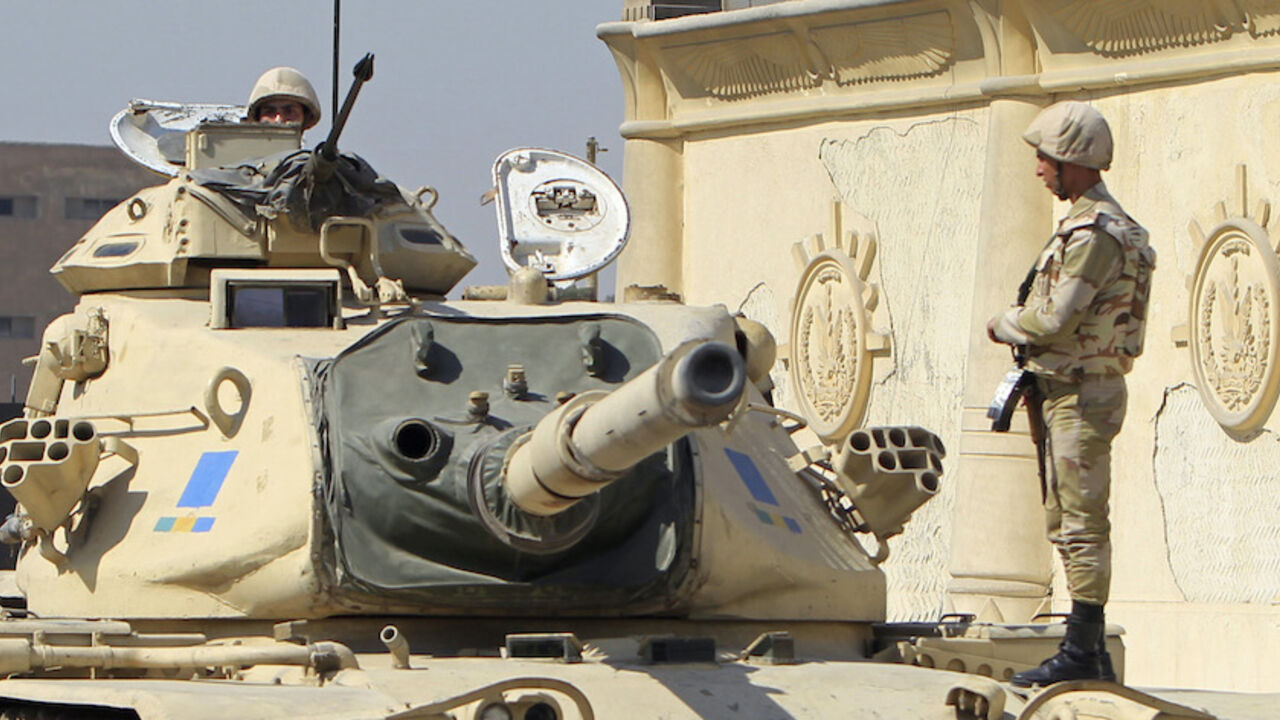 Egyptian army soldiers on a tank are positioned outside Cairo's Tora prison, where the trial of Al Jazeera journalists and other foreign media is due to take place, February 20, 2014. Egypt put three Al Jazeera journalists on trial on Thursday on charges of aiding Egyptians belonging to a "terrorist organisation", in a case criticised by human rights groups who say the authorities are stamping out freedom of expression. REUTERS/Mohamed Abd El Ghany (EGYPT - Tags: POLITICS CIVIL UNREST MILITARY) - RTX196JB