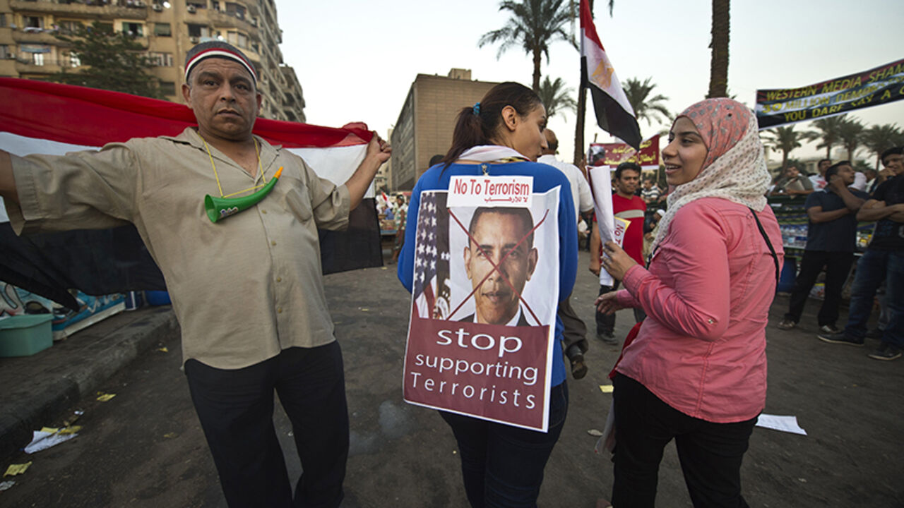 An Egyptian woman puts turns her back to show an image of US President Barack Obama with a slogan, as they rally in Cairo's Tahrir Square, on July 7, 2013. Opponents of Egypt's deposed Islamist president Mohamed Morsi packed Tahrir Square in their tens of thousands to show the world his ouster was not a military coup but the reflection of the people's will. AFP PHOTO / KHALED DESOUKI        (Photo credit should read KHALED DESOUKI/AFP/Getty Images)