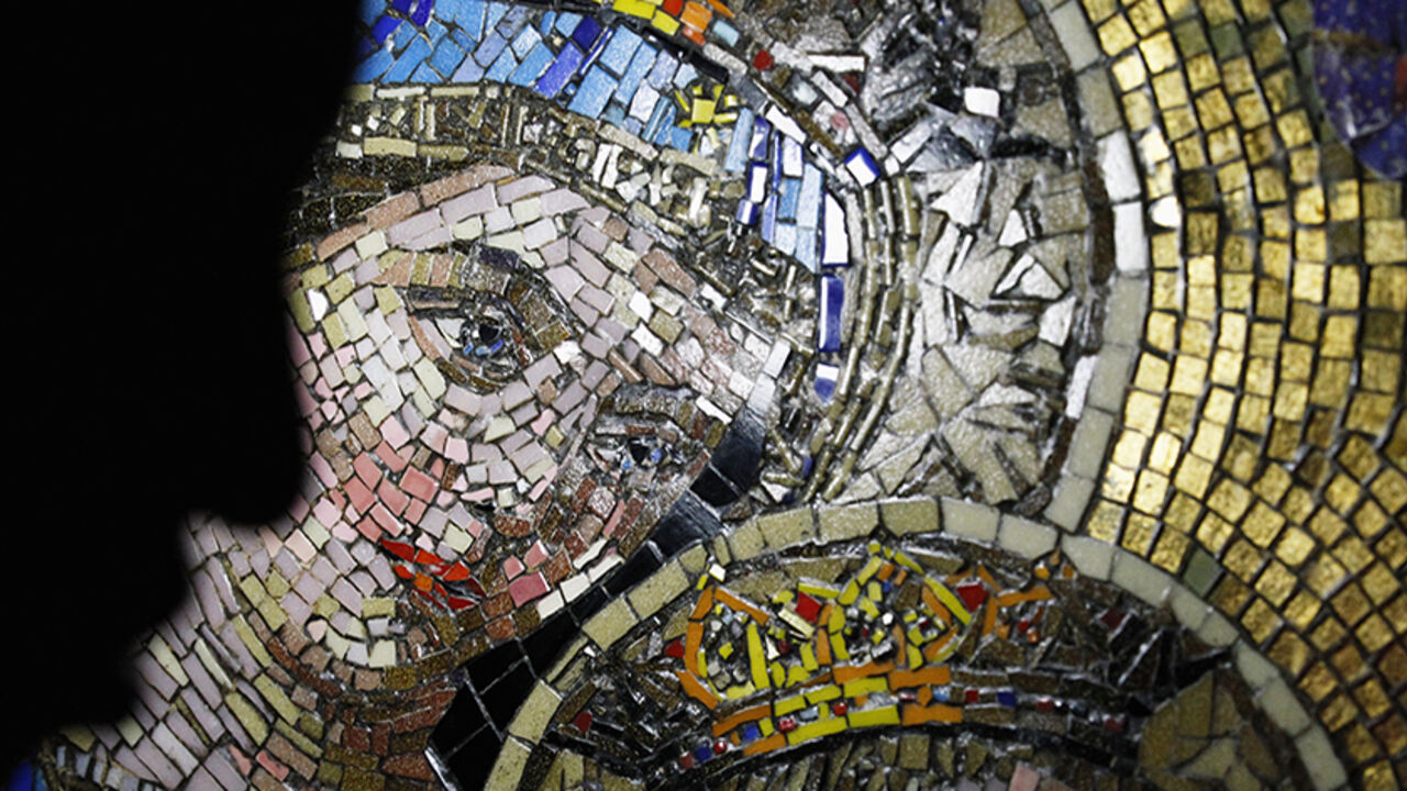 A visitor passes an image of the Virgin Mary, as thousands of Egyptian Copts celebrate the Feast of Assumption at the Virgin Mary Church in Mostorod, east of Cairo, August 22, 2014. The Feast of Assumption marks the Virgin Mary's ascension into heaven.  REUTERS/Mohamed Abd El Ghany (EGYPT - Tags: RELIGION SOCIETY) - RTR43DVG