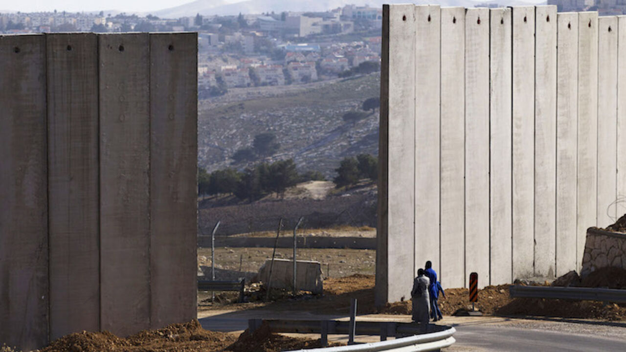 Palestinians walk near an opening in Israel's controversial barrier in the East Jerusalem neighbourhood of A-tur January 3, 2014. Israeli Prime Minister Benjamin Netanyahu offered a gloomy assessment of peace prospects with the Palestinians on Thursday as U.S. Secretary of State John Kerry began his 10th visit to the region in pursuit of a deal. Leaders from both sides have to address core issues of the decades-old conflict, such as the question of borders, security, refugees and the status of Jerusalem. RE