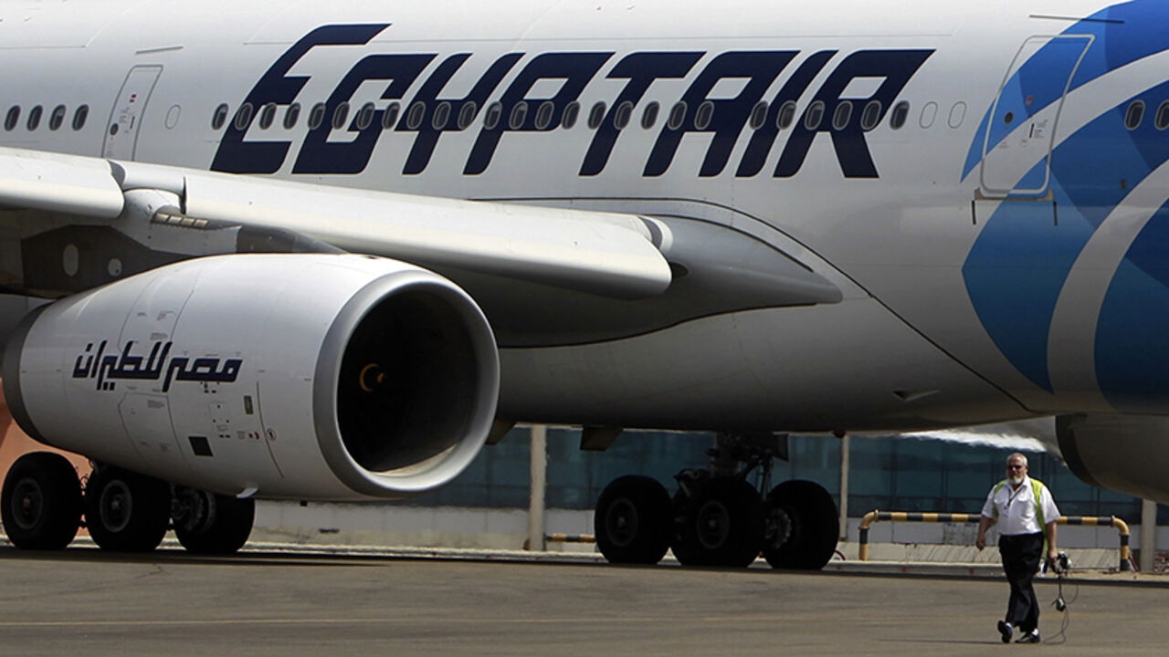 An airport staff walks next to an EgyptAir plane on the runway at Cairo Airport, September 5, 2013. The ongoing political crisis in Egypt has hit the once vibrant tourism industry hard, devastating a critical part of the country's economy. And with visitors scared away by civil strife in the aftermath of the ouster of President Mohamed Mursi, Egypt's national airliner, EgyptAir has been hit hard by the tourism slowdown. The airline has taken the brunt of losses in the tourism sector, losing billions of poun