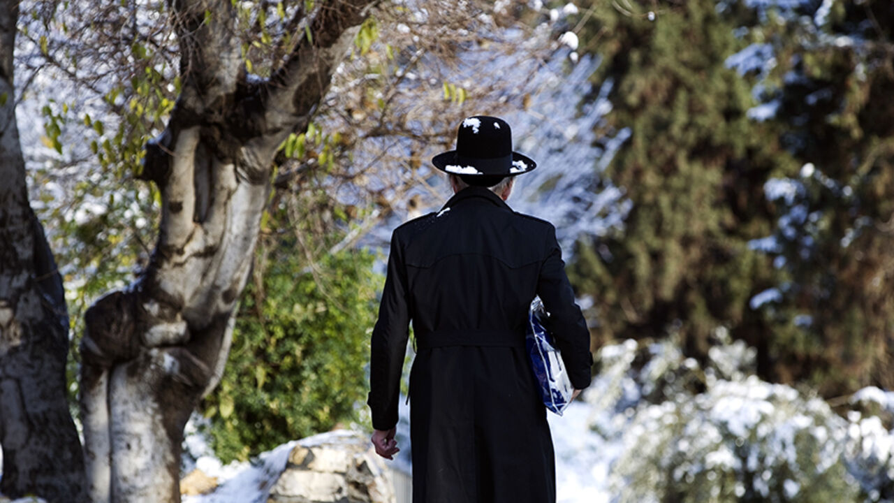 An Ultra-Orthodox Jewish man walks on a snow-covered street near Jerusalem's Old City January 10, 2015.  REUTERS/Ronen Zvulun (JERUSALEM - Tags: ENVIRONMENT RELIGION TPX IMAGES OF THE DAY) - RTR4KTNO