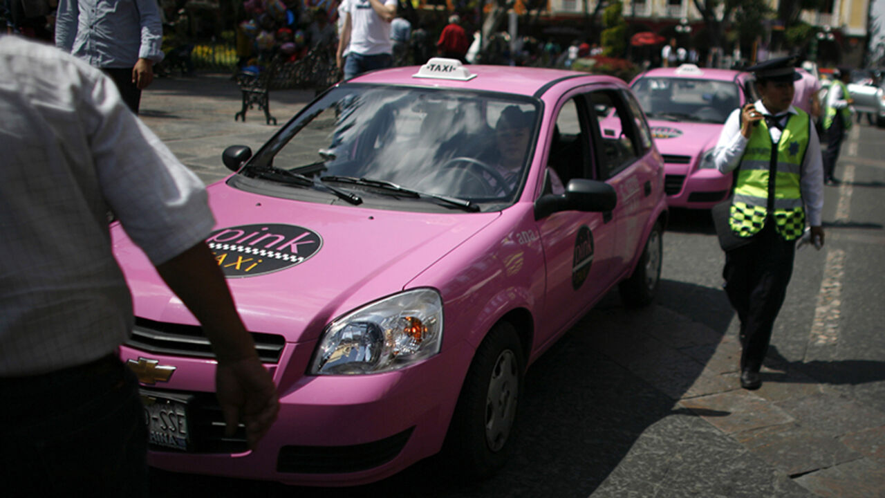 Two pink taxis wait in line in the city of Puebla October 23, 2009. The city recently launched thirty-five pink taxis, driven by 105 female cabbies, designated to pick up only female passengers. Each taxi is equipped with an alarm button and a GPS system.  REUTERS/Eliana Aponte (MEXICO TRANSPORT SOCIETY) - RTXPYAP