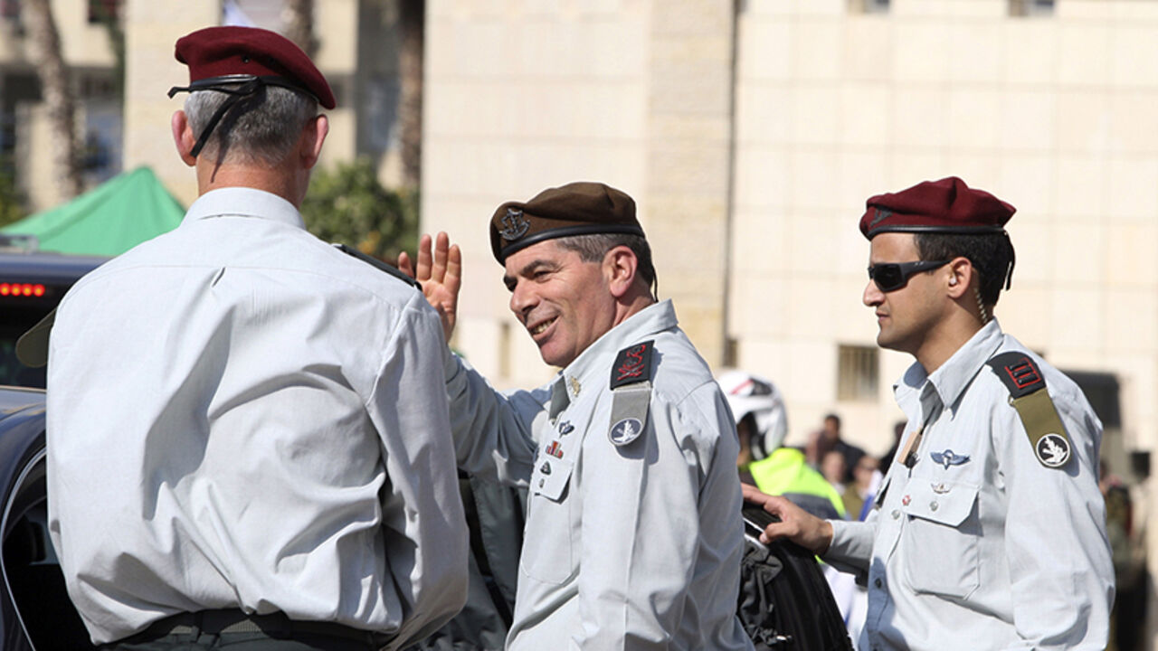 Outgoing Lieutenant-General Gabi Ashkenazi (C) waves to soldiers as he leaves after a handover ceremony in which he was replaced by the new Chief of Staff Lieutenant-General Benny Gantz (L) at the Kirya base in Tel Aviv February 14, 2011. REUTERS/Baz Ratner (ISRAEL - Tags: POLITICS MILITARY) - RTR2IL8L