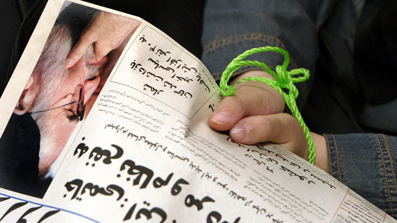 An Iranian journalist in symbolic rope shackle holds a copy of a banned reformist newspaper at a protest gathering in Tehran, July 26, 2004. More than 100 journalists gathered to protest against what they think is a fresh round of press crackdown in Iran. REUTERS/Raheb Homavandi  AP/DBP - RTR7D7P