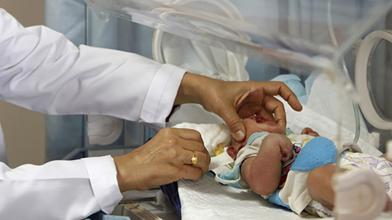 Pediatrician Samira al-Alani examines an anencephalic child in an incubator in a Falluja hospital, 50 km (31 miles) west of Baghdad, August 26, 2013. Alarmed by a rise in congenital anomalies in her city of Falluja, al-Aani launched a petition calling on the World Health Organisation (WHO) to release what she says are data collected more than a year ago on birth defects rates caused by the US-led 2003 war on Iraq for independent analysis. Picture taken August 26, 2013. REUTERS/Saad Shalash (IRAQ - Tags - Ta
