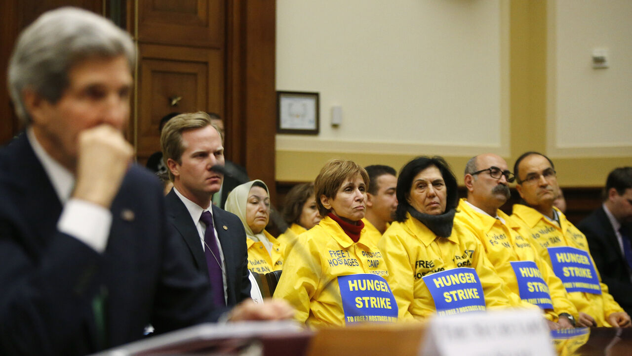 The U.S. families of Iranian dissidents, members of Iran's opposition movement Mujahedin-e Khalq (MEK) who reside in Camp Liberty in Iraq, look on as U.S. Secretary of State John Kerry testifies on agreements over Iran's nuclear programs, before the House Foreign Affairs Committee on Capitol Hill in Washington, December 10, 2013. REUTERS/Jonathan Ernst    (UNITED STATES - Tags: POLITICS MILITARY) - RTX16CNF