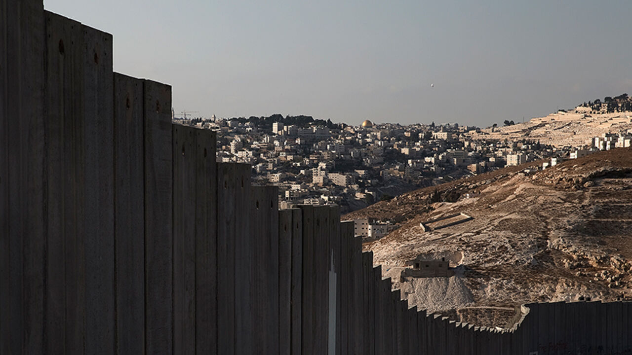 The golden Dome of the Rock (C) in Jerusalem's old city is seen in the distance beyond a section of the controversial Israeli barrier in the West Bank city of Abu Dis, October 29 , 2014. The Dome of the Rock is situated within the Al-Aqsa compound, known to Muslims as Noble Sanctuary and to Jews as Temple Mount. On the 25th anniversary of the fall of the Berlin Wall, there are still barriers separating communities around the world, from the barbed wire fence dividing the two Koreas, the fence around the Spa