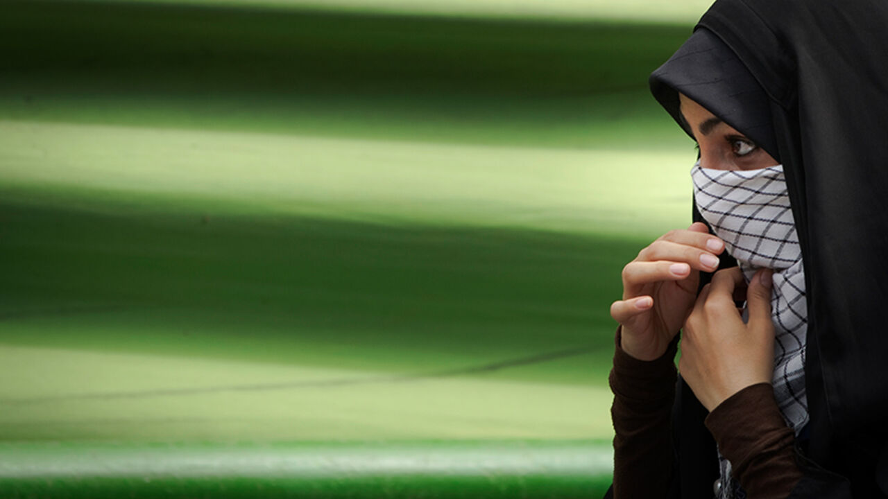 An Iranian woman adjusts her face veil as she participates in the Jerusalem Day demonstration in Tehran August 26, 2011 . REUTERS/Caren Firouz (IRAN - Tags: POLITICS CIVIL UNREST) - RTR2QC5V