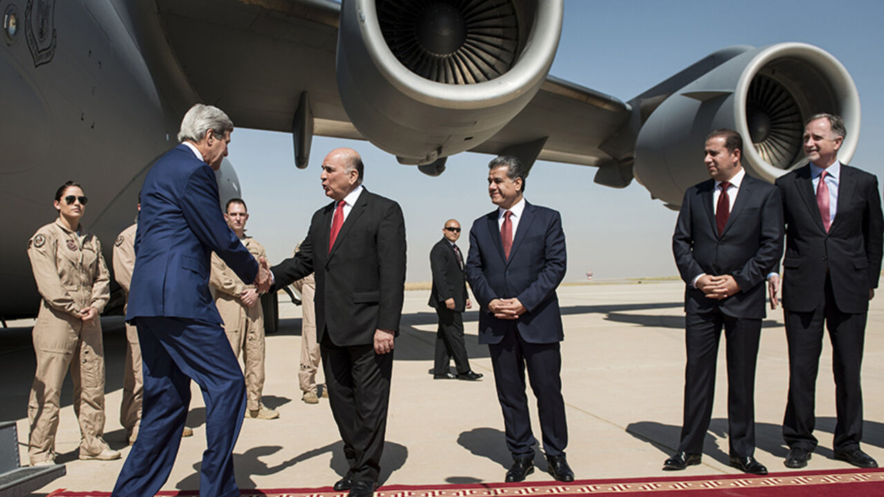 Kurdish regional foreign relations minister Falah Mustafa Bakir (C) and other officials look on as US Secretary of State John Kerry (L) is greeted by Fuad Hussein, chief of staff at the presidency of the Kurdistan regional government, at Arbil International Airport on June 24, 2014. Kerry met in Arabil, the capital of northern Iraq's Kurdistan autonomous region, with regional government president Massud Barzani  (unseen) as part of a US diplomatic drive aimed at preventing the country from splitting apart i