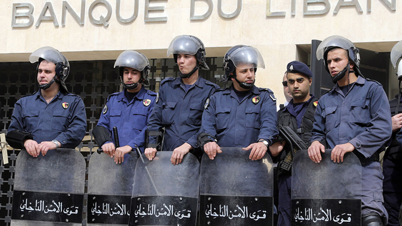 Lebanese riot police stand guard at the Lebanese Central Bank in Beirut February 25, 2013. An open-ended strike by teachers and civil servants entered its second week today for the government to approve the wage hike proposal. REUTERS/Mohamed Azakir (LEBANON - Tags: POLITICS CIVIL UNREST) - RTR3E9U4