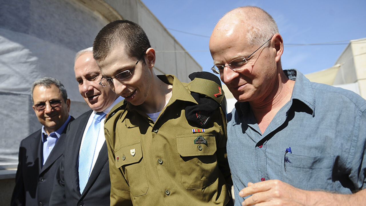 Gilad Shalit (2nd R) walks with his father Noam (R), Israel's Prime Minister Benjamin Netanyahu and Defence Minister Ehud Barak (L) at Tel Nof air base in central Israel in this handout released by the Prime Minister's Office (PMO) October 18, 2011. Israeli soldier Gilad Shalit returned home to a national outpouring of joy on Tuesday after five years in captivity as hundreds of Palestinian prisoners exchanged for him were greeted with kisses from Hamas leaders in the Gaza Strip. REUTERS/PMO/Handout (ISRAEL 