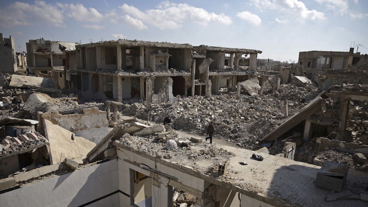 People walk past damaged buildings in the Douma neighbourhood of Damascus, Syria February 9, 2016. REUTERS/Bassam Khabieh        TPX IMAGES OF THE DAY - RTX267OK