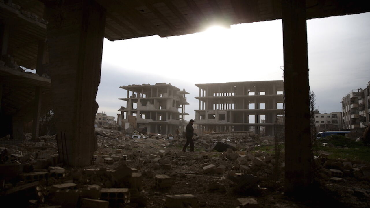 A man walks on the rubble of damaged buildings in the rebel-controlled area of Jobar, a suburb of Damascus, Syria March 2, 2016. REUTERS/Bassam Khabieh - RTS8ZZ9
