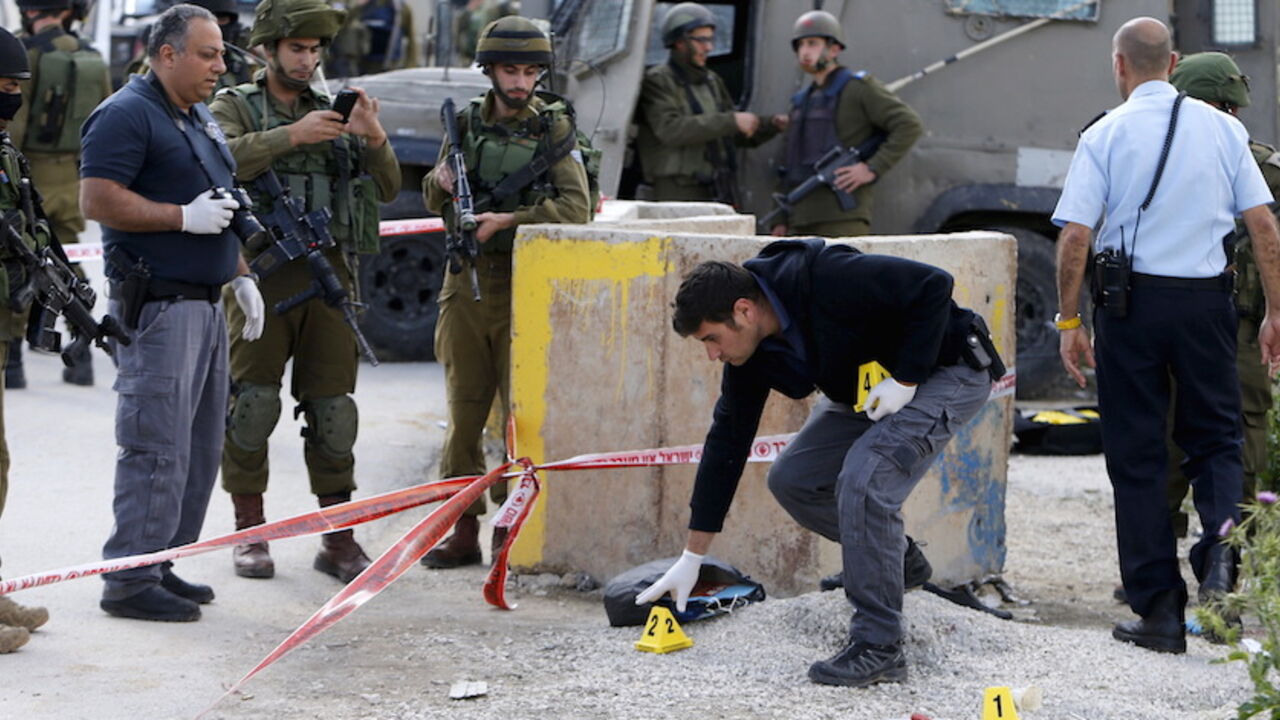 Israeli forces inspect the scene where a Palestinian, whom the Israeli military said attacked Israeli soldiers with an axe, was shot dead at the entrance of Arroub refugee camp, north of the West Bank city of Hebron April 14, 2016. REUTERS/Mussa Qawasma       TPX IMAGES OF THE DAY      - RTX29Y9E