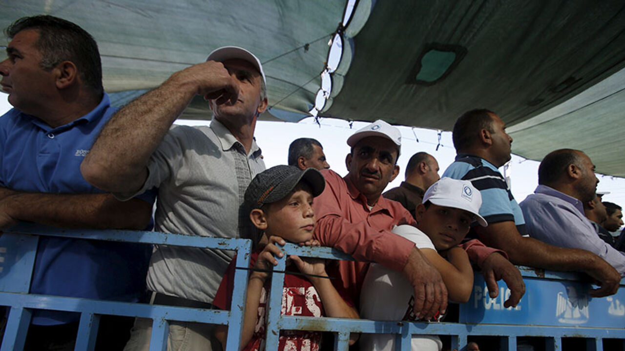 Palestinians wait to show their permits to Israeli security officers as they make their way to attend the fourth Friday prayer of Ramadan in Jerusalem's al-Aqsa mosque, at an Israeli checkpoint in the West bank city of Bethlehem July 10, 2015. REUTERS/Mussa Qawasma - RTX1JTWR