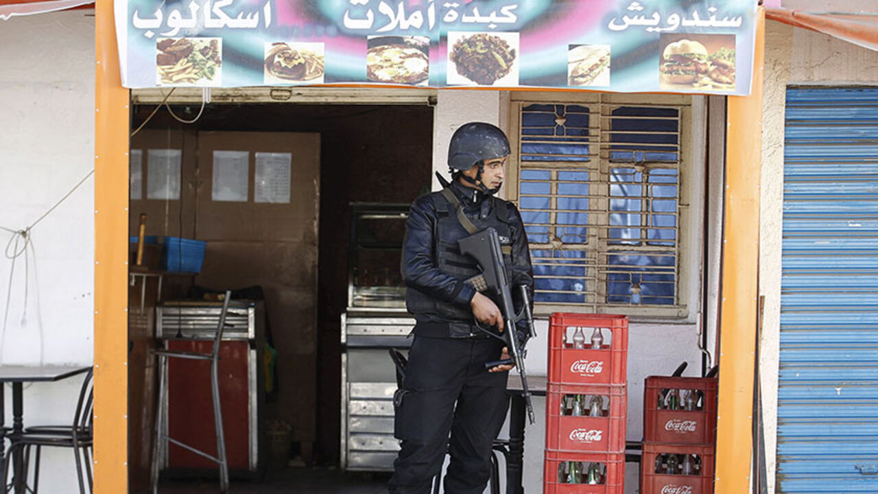 A Tunisian police officer stands guard near a police station after Monday's attack by Islamic State militants on army and police barracks in the town of Ben Guerdan, Tunisia, near the Libyan border March 8, 2016. REUTERS/Zoubeir Souissi - RTS9UV0