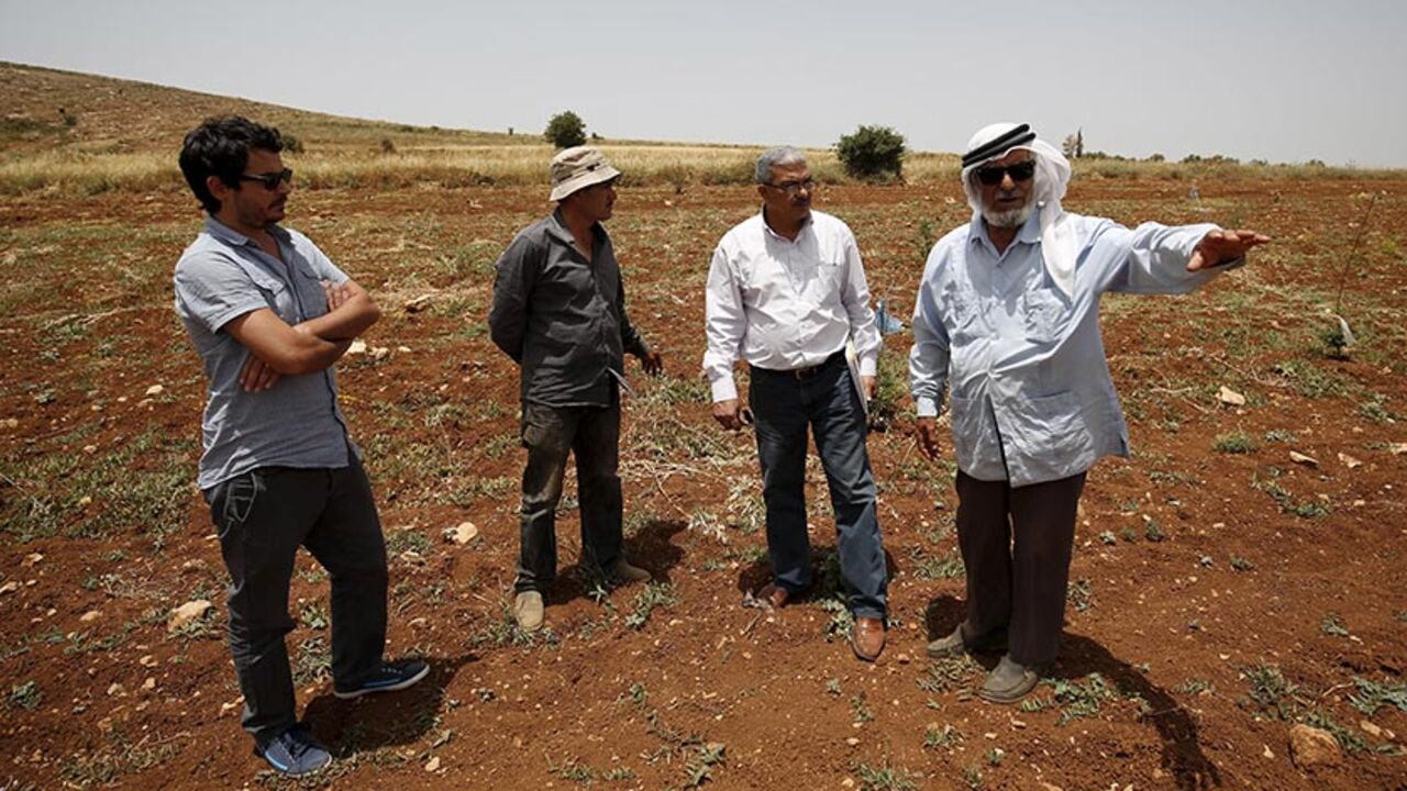 B'Tselem field researcher Iyad Hadad (2nd R) listens to a testimony from a Palestinian farmer, who said his land was damaged in an attack by Israeli settlers, in the West Bank village of Turmus Aya near Ramallah June 8, 2015. B'Tselem is an Israeli NGO that has long been a bane of the government, tirelessly flagging human rights abuses by Israel's military in the Palestinian territories. Set up by a group of academics, lawyers, journalists and politicians more than 25 years ago, the organisation - whose nam