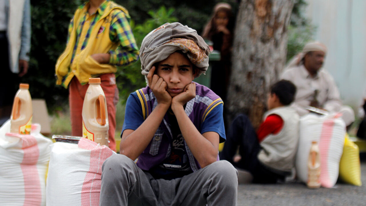 A boy sits next to food supplies he received from a local charity in Sanaa, Yemen, June 23, 2016. REUTERS/Mohamed al-Sayaghi - RTX2HU73