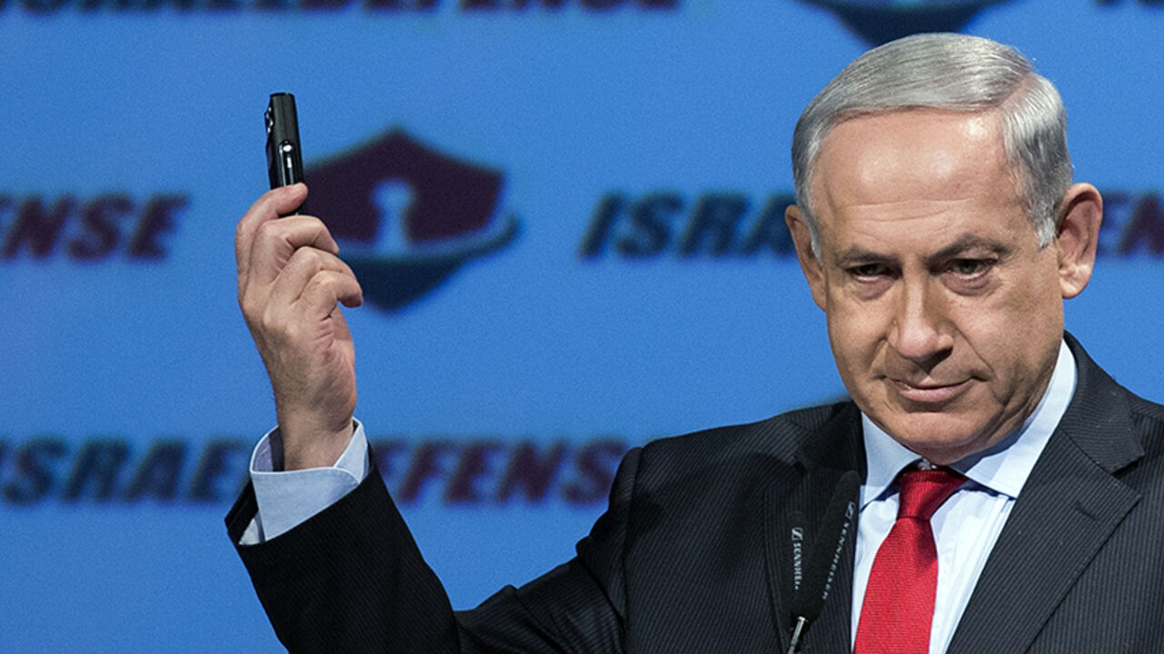 Israeli Prime Minister Benjamin Netanyahu shows a mobile phone, saying how unprotected electronic devices are, during his opening speech of the "CyberTech 2014" international conference on January 27, 2014 in the Mediterranean coastal city of Tel-Aviv. The event runs until January 27. AFP PHOTO / JACK GUEZ        (Photo credit should read JACK GUEZ/AFP/Getty Images)