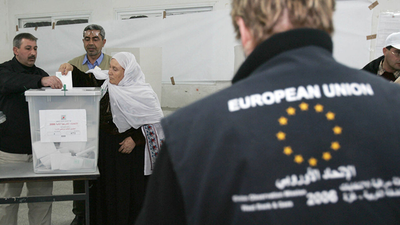 GAZA CITY, GAZA STRIP - JANUARY 25: A member of a European Union mission to observe the parliamentary elections in the West Bank and Gaza monitor Palestinians  as they vote for the Palestinian legislative candidates at a polling station in the U.N. school Alef which is being used as an election station on January 25 2006, in Gaza City, Gaza Strip.The newly elected Palestinian Legislative Council (PLC) will be expanded, and half of the seats will be allotted by proportional representation of all parties that