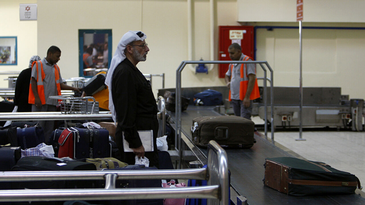 A traveller waits for his luggage at the Allenby Bridge Crossing July 9, 2009. Israel said on Wednesday it would allow the crossing between the occupied West Bank and Jordan to remain open 24 hours a day to help the Palestinian economy. The Israeli-controlled terminal leading to the Allenby Bridge across the Jordan River is the West Bank's only land link to the Arab world.  REUTERS/Ammar Awad (WEST BANK POLITICS) - RTR25HFS