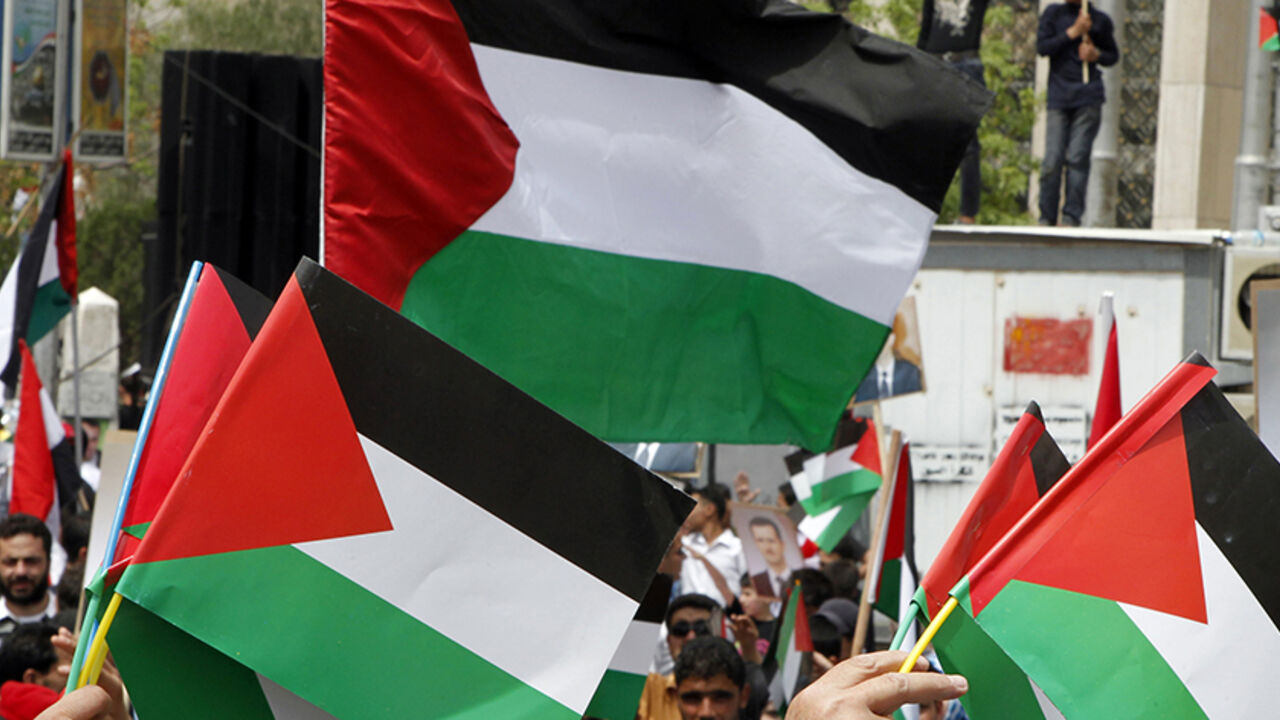 People hold up Baath Party flags during a rally to commemorate the 65th anniversary of the foundation of the party at al-Sabaa Bahrat square in Damascus April 7, 2012. The Baath Party has ruled Syria since 1963. REUTERS/Khaled al-Hariri (SYRIA - Tags: ANNIVERSARY POLITICS ) - RTR30GAR