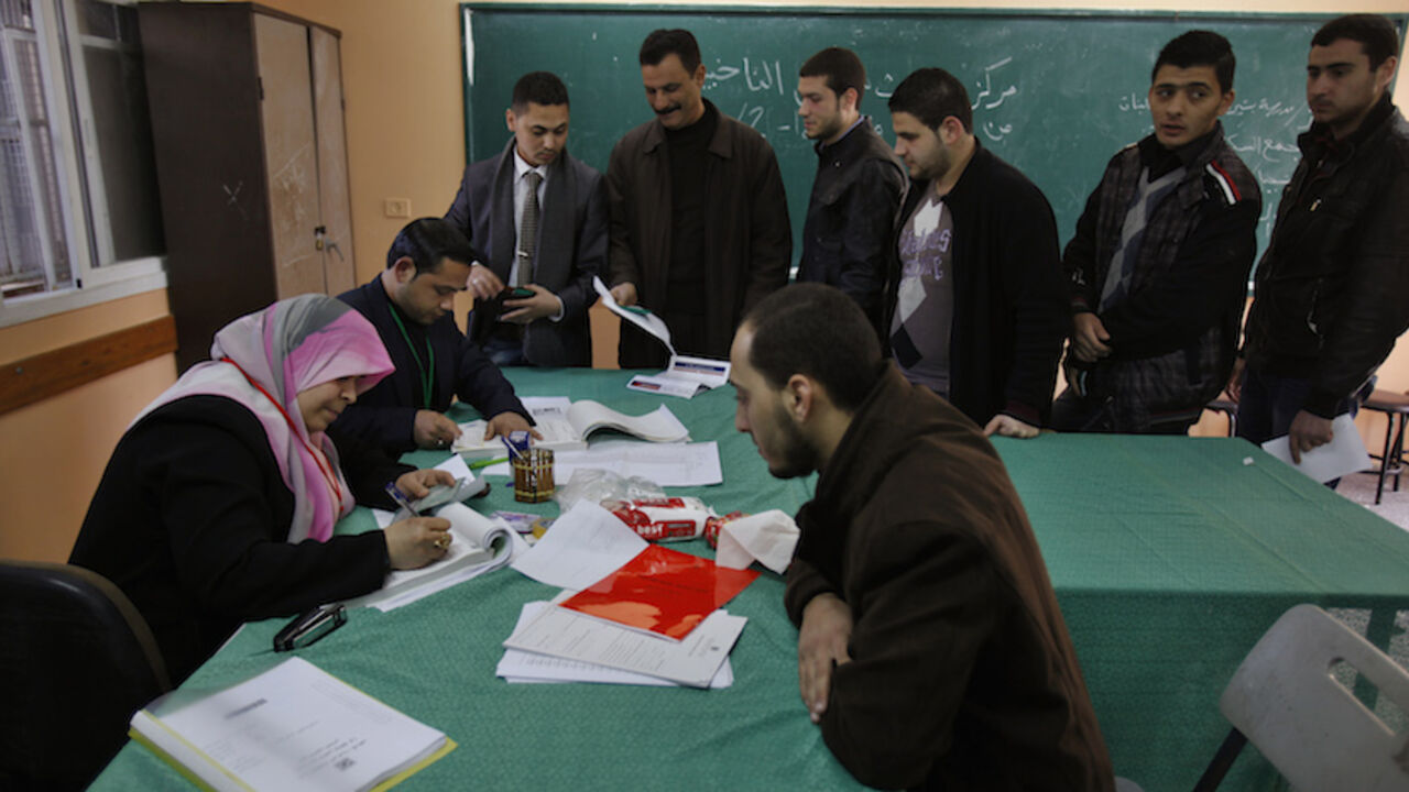 Palestinians update their details at a centre run by the Palestinian Central Election Commission (CEC), in Gaza City February 11, 2013.The Palestinian Central Election Commission on Monday began registering voters in Gaza and the West Bank for an upcoming election hoped to help with healing nearly six years of political rifts among rival factions.  REUTERS/Ibraheem Abu Mustafa (GAZA - Tags: POLITICS ELECTIONS) - RTR3DMR0