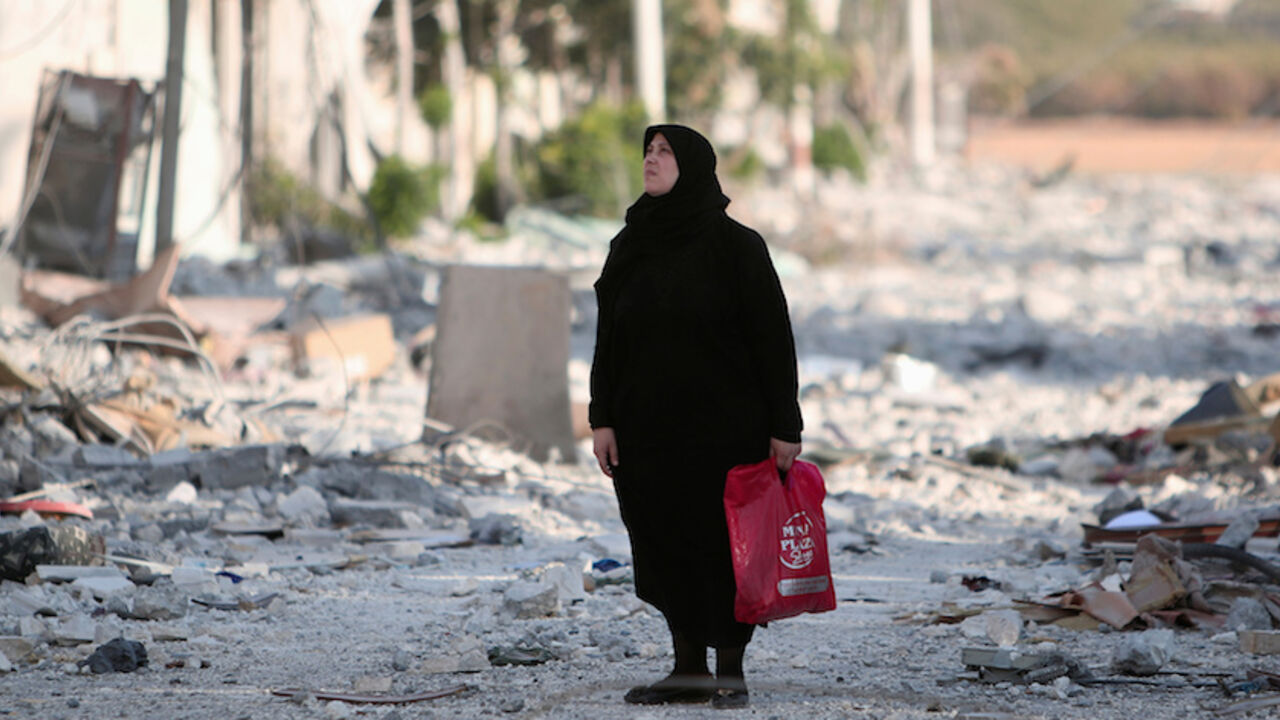 A woman stands along a damaged street in Manbij, Aleppo Governorate, Syria, August 16, 2016. REUTERS/Rodi Said - RTX2LBQT