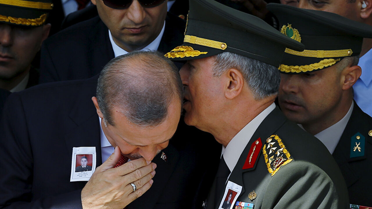 Turkey's Chief of Staff General Hulusi Akar whispers in President Tayyip Erdogan's ear during the funeral of Sergeant Okan Tasan, one of the soldiers killed during an attack on a military convoy and clashes on Sunday in the mountainous Daglica area of Hakkari province, at Kocatepe Mosque in Ankara, Turkey, September 10, 2015. Pro-Kurdish politicians, including cabinet ministers, attempted to march to a town in southeast Turkey on Thursday to protest a week-old curfew there, as their party came under fire fr