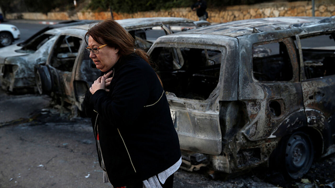 A resident stands next to burnt cars from Thursday's fire in the northern city of Haifa, Israel November 25, 2016. REUTERS/Baz Ratner - RTST83G