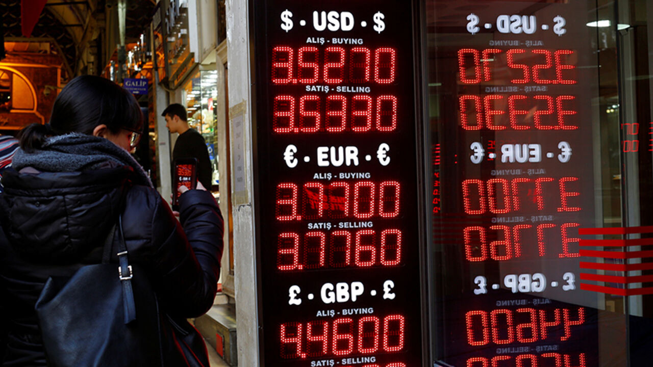 A woman uses her mobile phone to take a picture of a display board at a currency exchange office at the Grand Bazaar in Istanbul, Turkey, December 5, 2016. Picture taken December 5, 2016. REUTERS/Murad Sezer - RTSUWLI