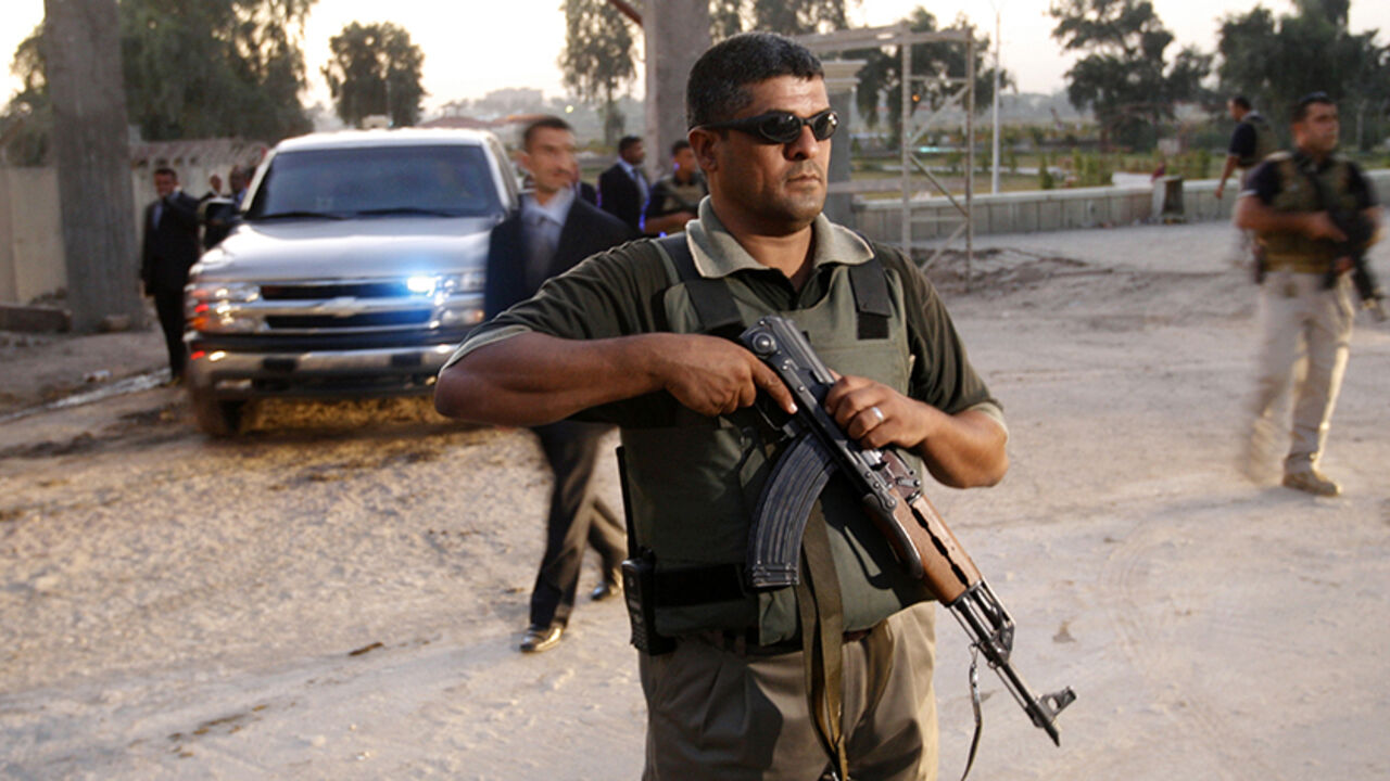 Security personnel guard the area as the vehicle of Iraq's Prime Minister Nuri al-Maliki leaves after visiting the newly restored Abu Nawas Road in Baghdad November 5, 2007.             REUTERS/Ceerwan Aziz (IRAQ) - RTR1VOPP