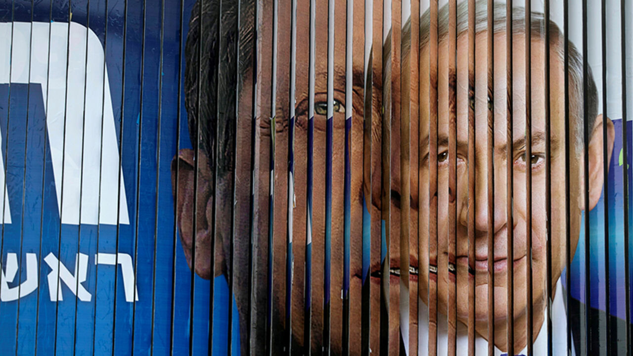 Israel's Prime Minister Benjamin Netanyahu (R) and Isaac Herzog, co-leader of the Zionist Union party, are pictured together as campaign billboards rotate in Tel Aviv, March 9, 2015. REUTERS/Baz Ratner/File Photo - RTSEUAF