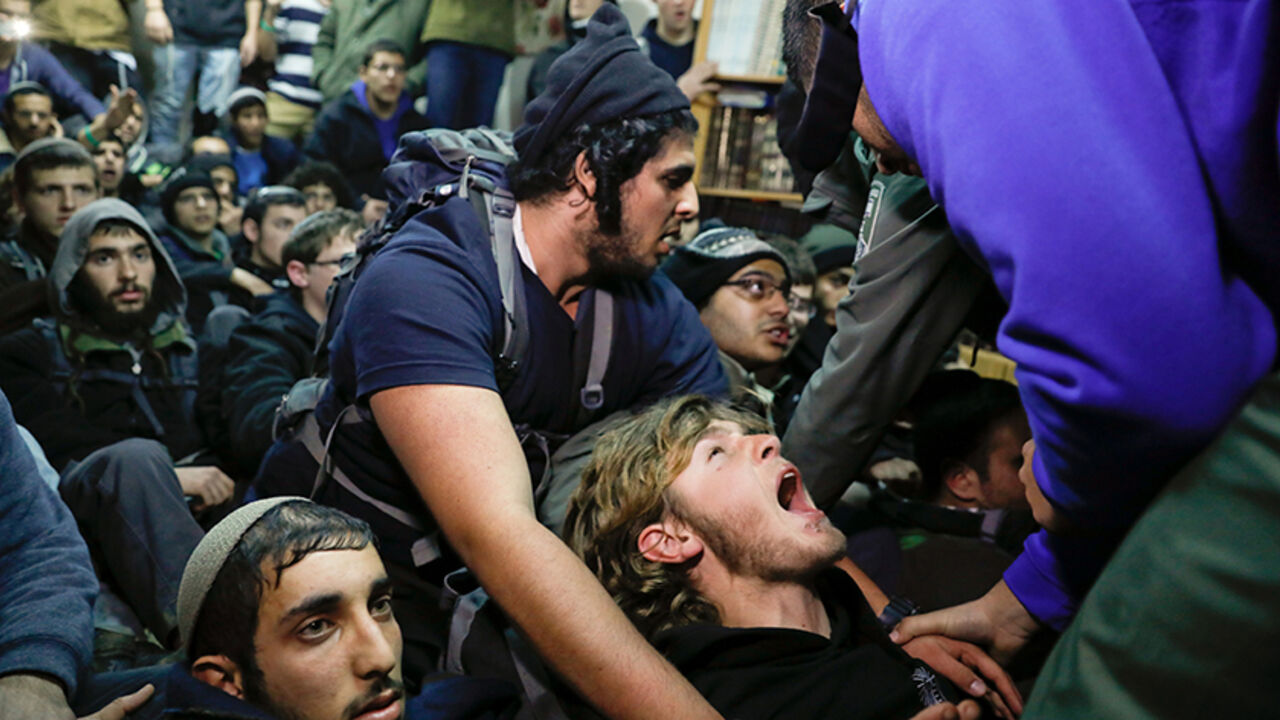 Israeli policemen try to remove pro-settlement activists from a house during an operation by Israeli forces to evict settlers from the illegal outpost of Amona in the occupied West Bank February 1, 2017. REUTERS/Ronen Zvulun      TPX IMAGES OF THE DAY - RTX2Z6O2