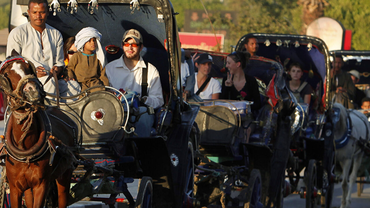 Tourists ride on horse carts in the southern city of Luxor December 2, 2010. REUTERS/Asmaa Waguih (EGYPT - Tags: TRAVEL SOCIETY) - RTXVBMW