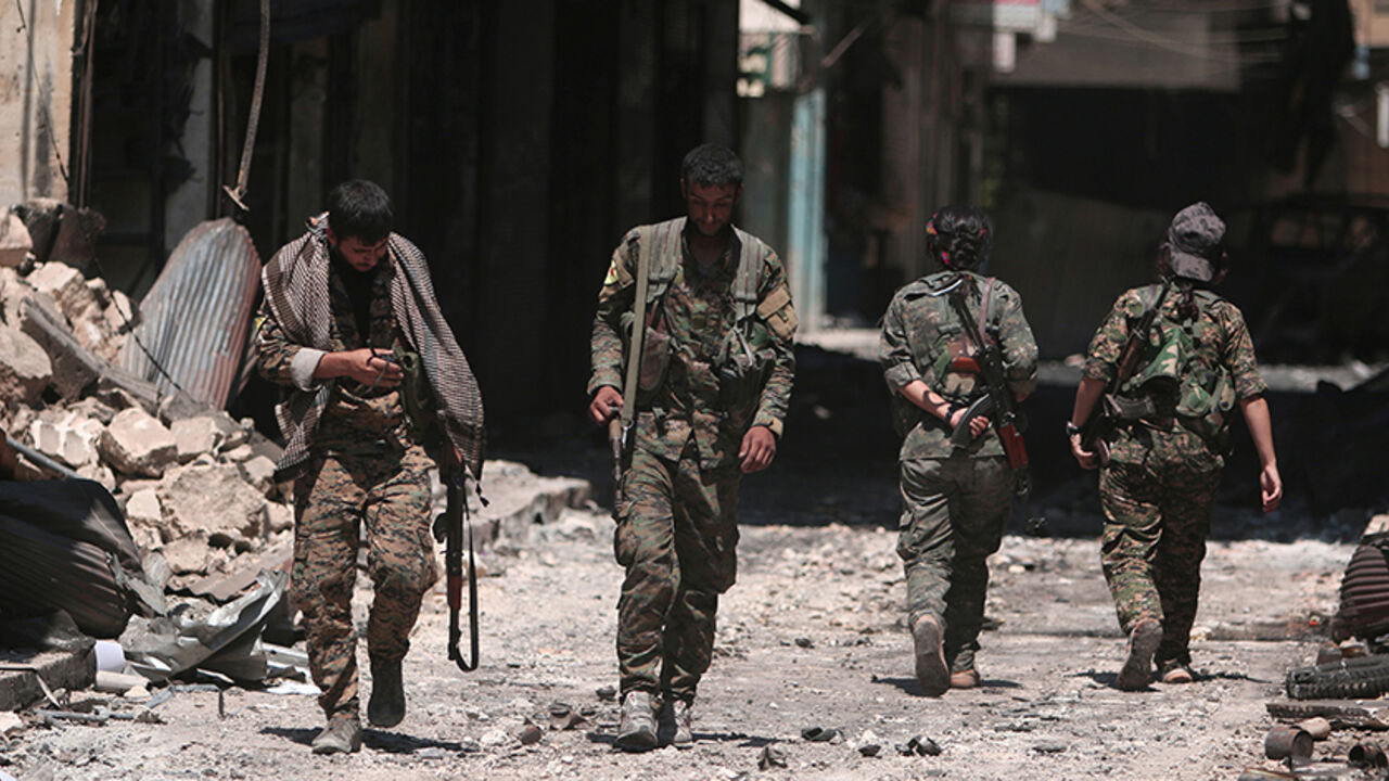 Syria Democratic Forces (SDF) fighters walk on the rubble of damaged shops and buildings in the city of Manbij, in Aleppo Governorate, Syria, August 10, 2016. REUTERS/Rodi Said - RTSMDAF