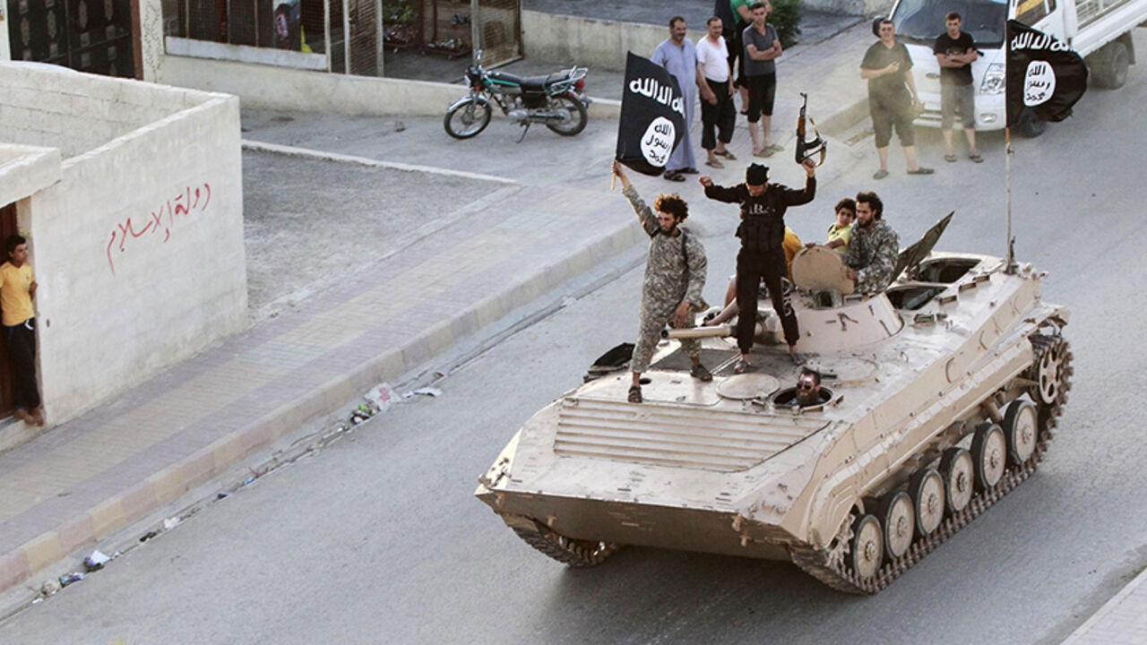 Militant Islamist fighters take part in a military parade along the streets of northern Raqqa province June 30, 2014. Militant Islamist fighters held a parade in Syria's northern Raqqa province to celebrate their declaration of an Islamic "caliphate" after the group captured territory in neighbouring Iraq, a monitoring service said. The Islamic State, an al Qaeda offshoot previously known as Islamic State in Iraq and the Levant (ISIL), posted pictures online on Sunday of people waving black flags from cars 
