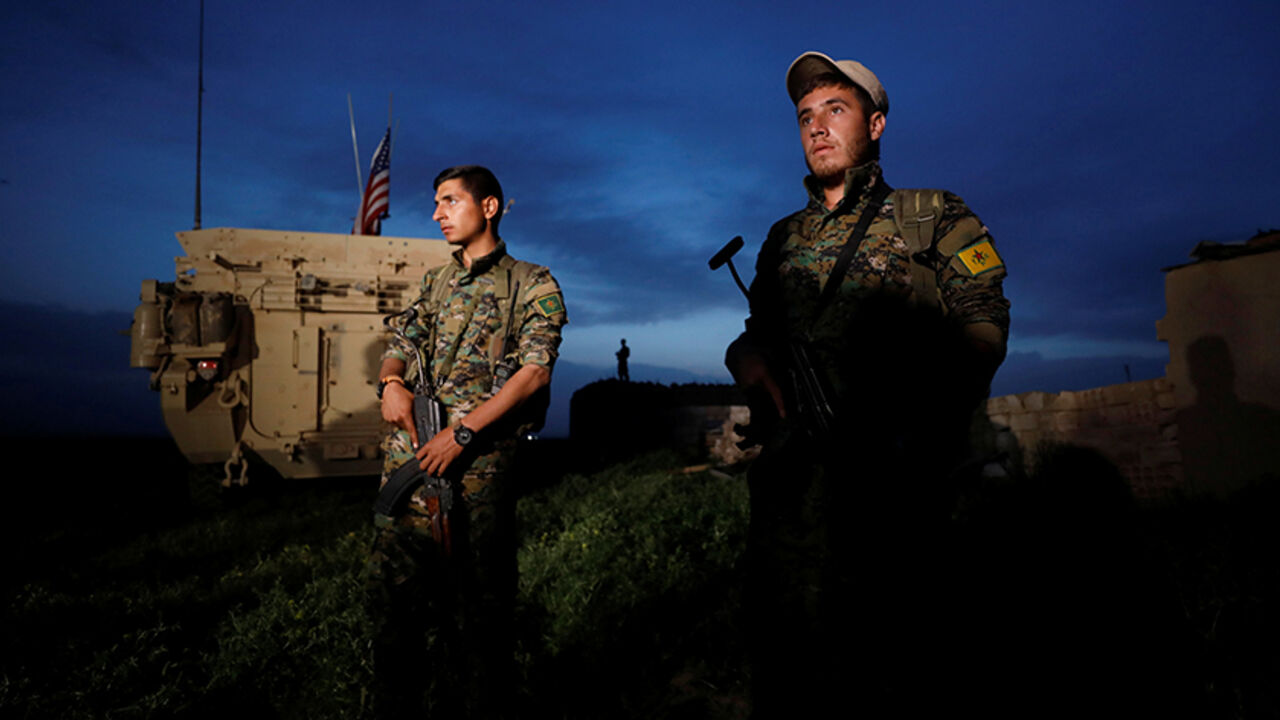 Kurdish fighters from the People's Protection Units (YPG) stand near a U.S military vehicle in the town of Darbasiya next to the Turkish border, Syria April 28, 2017. REUTERS/Rodi Said - RTS14EG4
