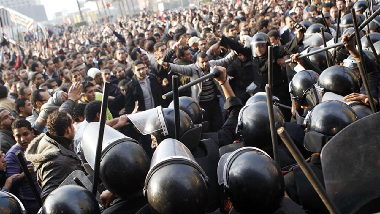 Anti-government protesters demonstrate near riot police at Tahrir Square in downtown Cairo January 25, 2011. Thousands of Egyptians demanded an end to President Hosni Mubarak's 30-year rule and clashed with police on Tuesday, in unprecedented protests inspired by the revolt that brought down Tunisia's president.  REUTERS/Amr Abdallah Dalsh  (EGYPT - Tags: CIVIL UNREST POLITICS) - RTXX2LD