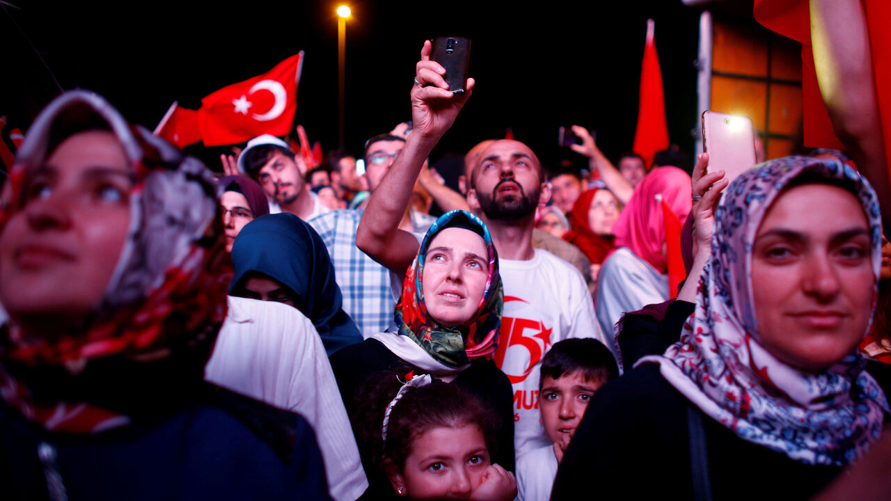 People listen to the speech of Turkey's President Tayyip Erdogan during a ceremony marking the first anniversary of the attempted coup at the Bosphorus Bridge in Istanbul, Turkey, July 15, 2017. REUTERS/Osman Orsal     TPX IMAGES OF THE DAY - RTX3BLUL