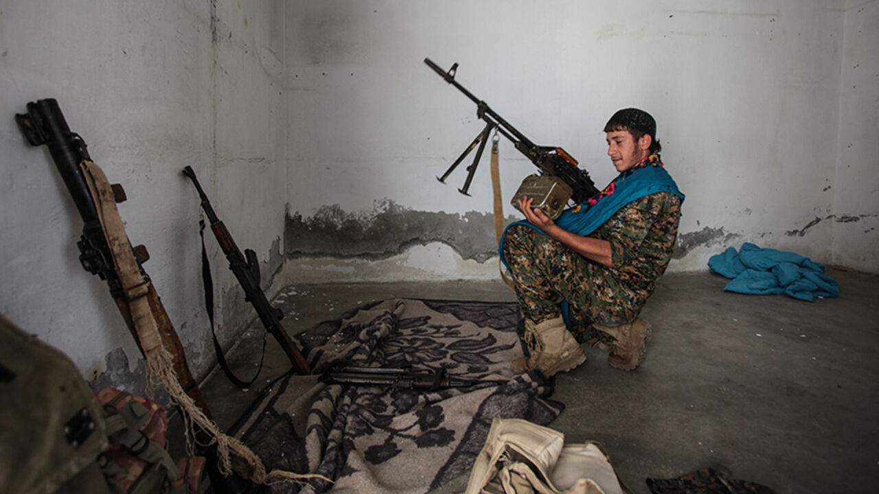 TAL ABYAD, SYRIA - JUNE 19: (TURKEY OUT) A Kurdish People's Protection Units, or YPG fighter controls the weapons in downtown of Tal Abyad, Syria. June 19, 2015. Kurdish fighters with the YPG took full control of Tal Abyad, dealing a major blow to the Islamic State group's ability to wage war in Syria. Mopping up operations have started to make the town safe for the return of residents from Turkey, after more than a year of Islamic State militants holding control of the town. (Photo by Ahmet Sik/Getty Image
