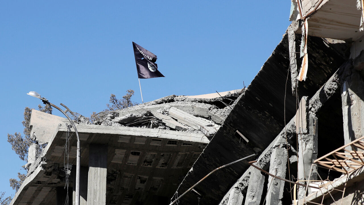 A flag of Islamic State militants is pictured above a destroyed house near the Clock Square in Raqqa, Syria October 18, 2017. Picture taken October 18, 2017.     REUTERS/Erik De Castro - RC159E696010